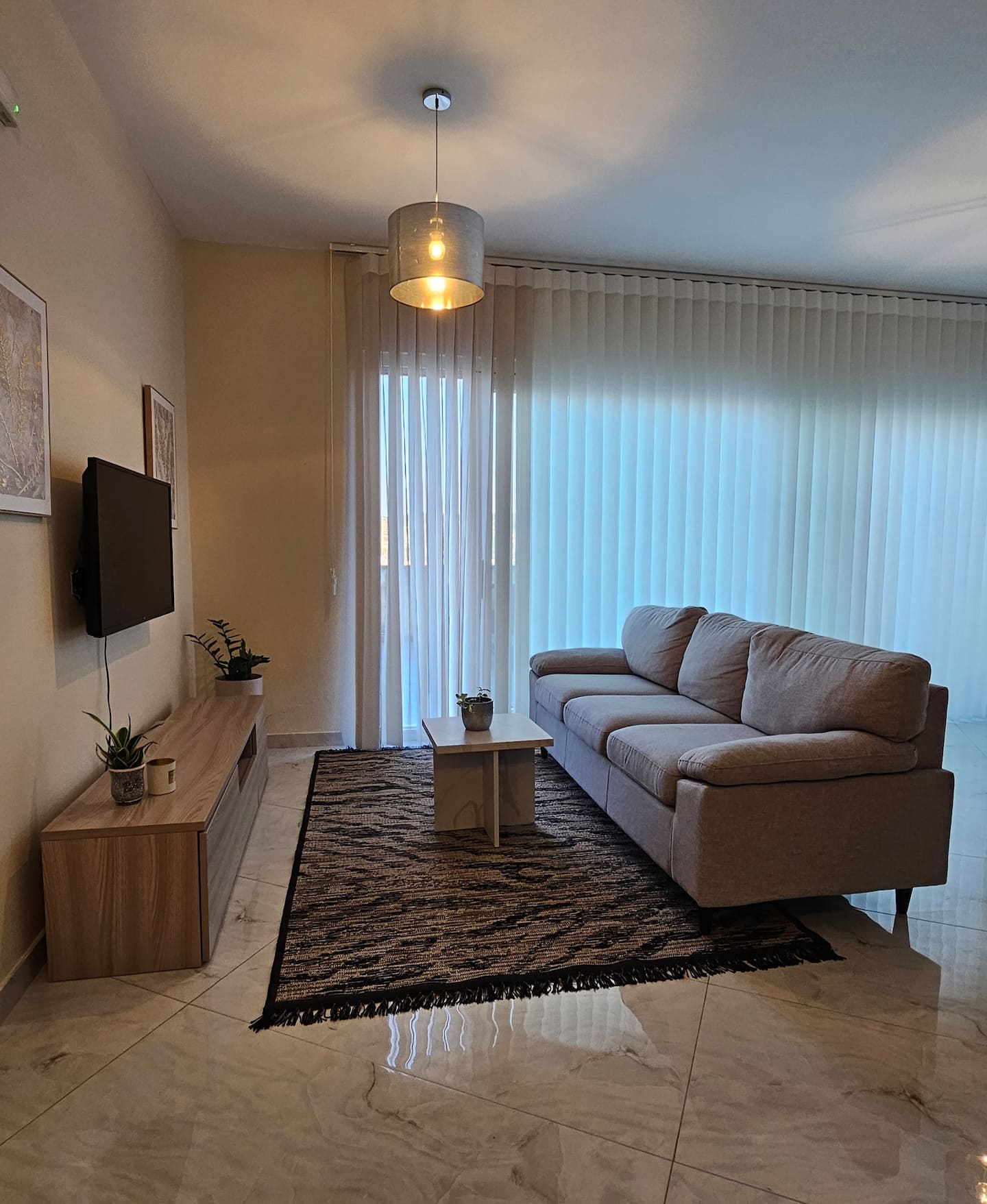 Penthouse living room with sofa, TV and balcony doors